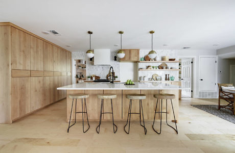 Minimalist kitchen with light wood cabinetry and pendant lighting.