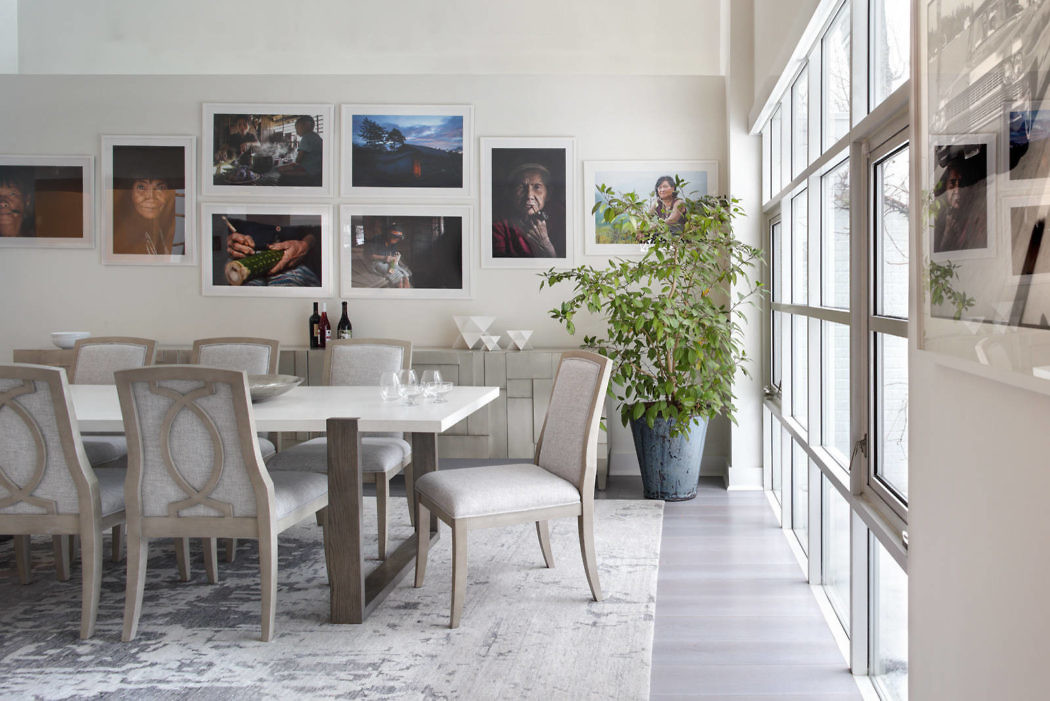 Contemporary dining room with art gallery wall and floor-to-ceiling windows.