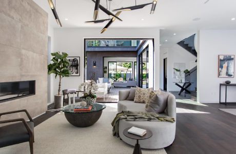 Contemporary living room with sleek furnishings and large windows.