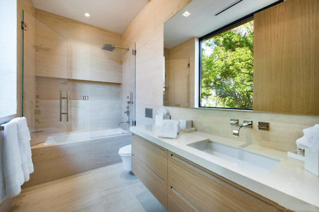 Modern bathroom with a large window view of greenery.
