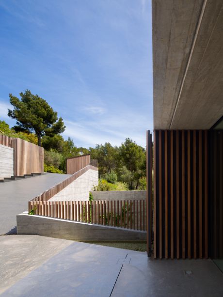 Contemporary concrete and wood exterior with stairway and slatted details.