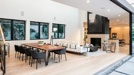 Modern living room interior with dining area and open sliding doors.