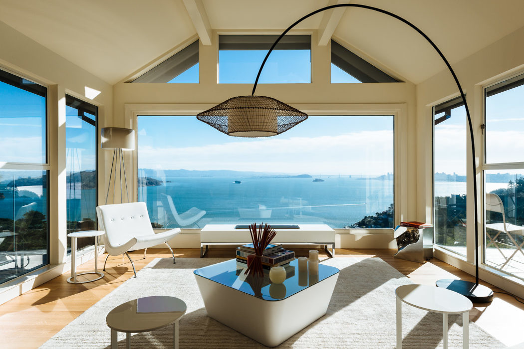 Bright living room with large windows overlooking the sea.