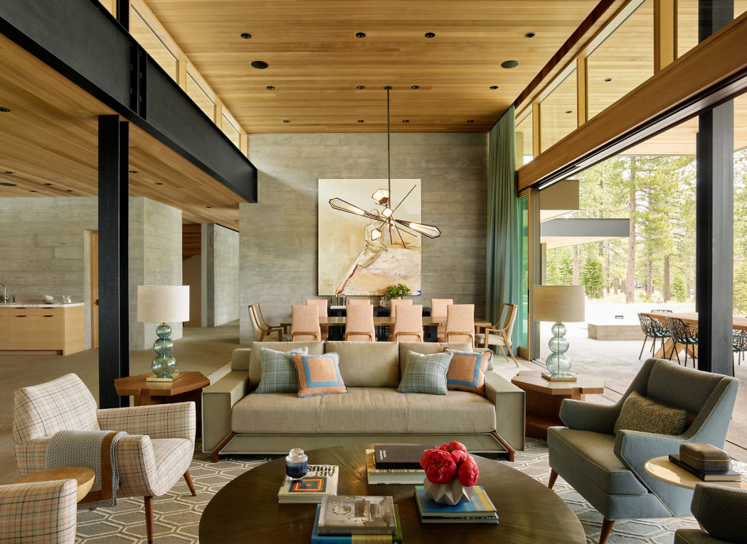 Contemporary living room with wooden ceilings, plush seating, and large windows.