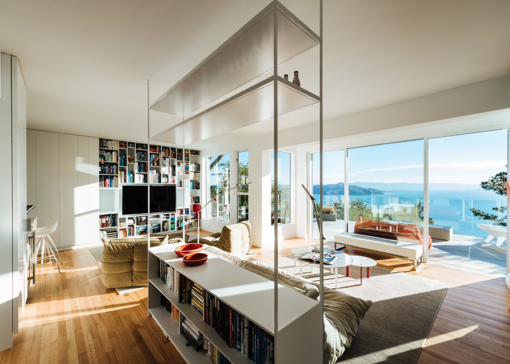 Bright open-plan living space with floor-to-ceiling windows and sea view.