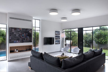 Contemporary living room with large windows and pool view.