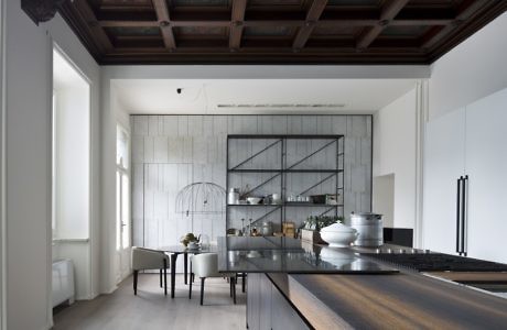 Contemporary kitchen with sleek furnishings and exposed wooden beams.