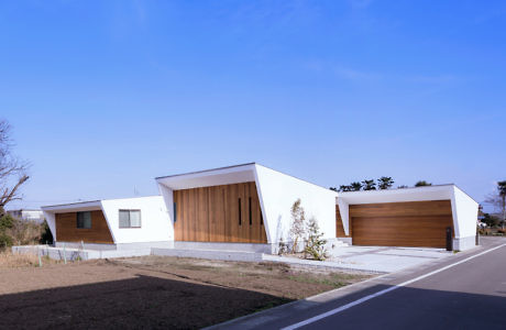 Angular white homes with wood accents under a clear sky.