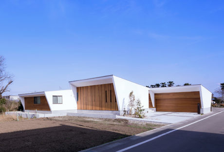 Angular white homes with wood accents under a clear sky.