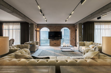 Chic industrial-style living room with exposed brick and plush seating.