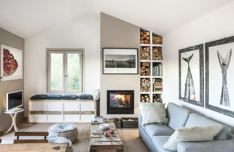 Modern living room with fireplace, artwork, and built-in bookshelf.