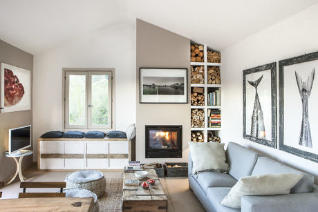 Modern living room with fireplace, artwork, and built-in bookshelf.