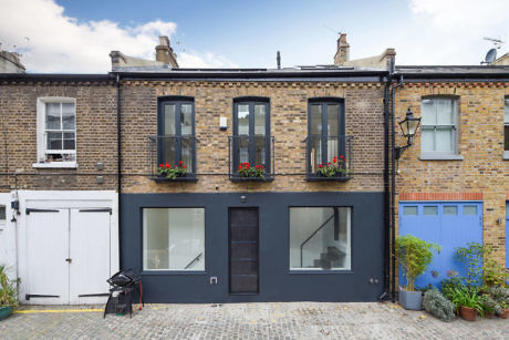 Front view of a charming mews house with contrasting modern windows and a traditional brick
