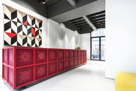 Modern interior with red credenza, geometric wall art, white sculptural wall,