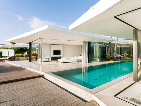 Modern house with pool, terrace, and sliding glass doors.