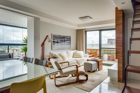 Modern living room interior with furniture and city view from balcony.