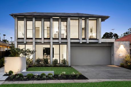 Modern two-story house with large windows and a double garage at dusk.