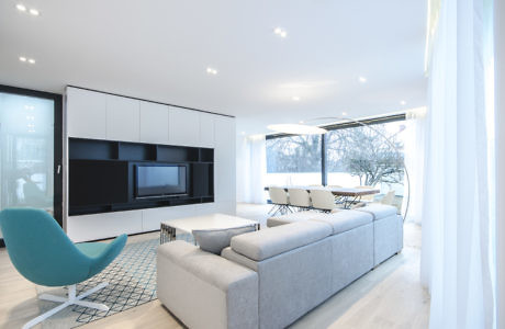 Contemporary living room with sleek furnishings and large windows.