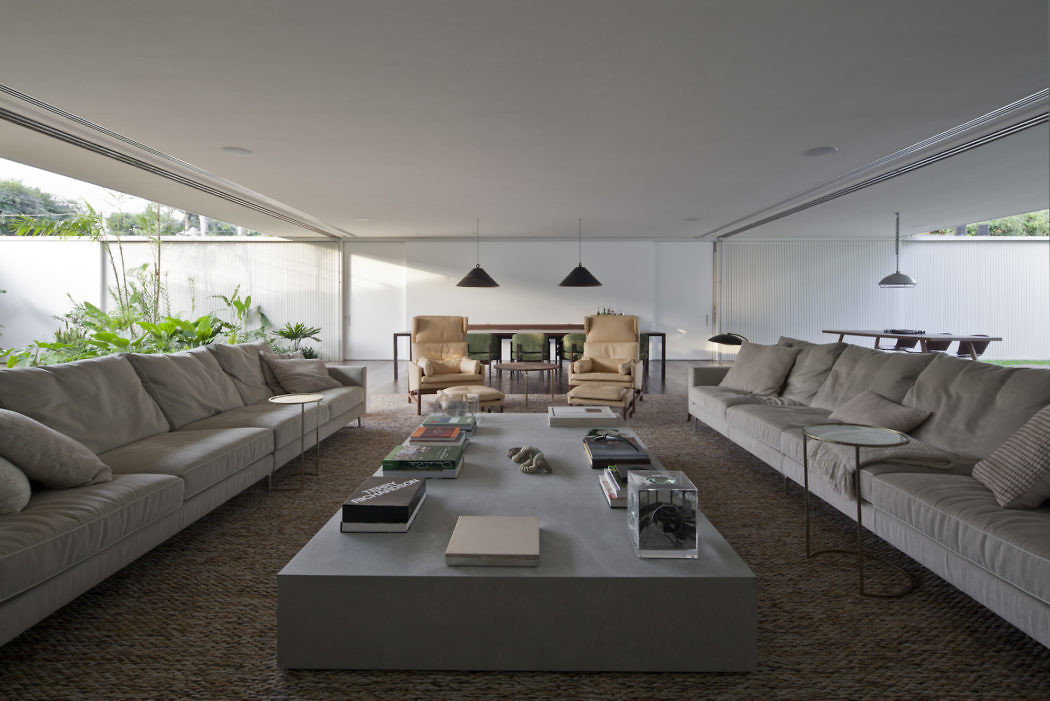 Minimalist living room with large sofas and central coffee table.
