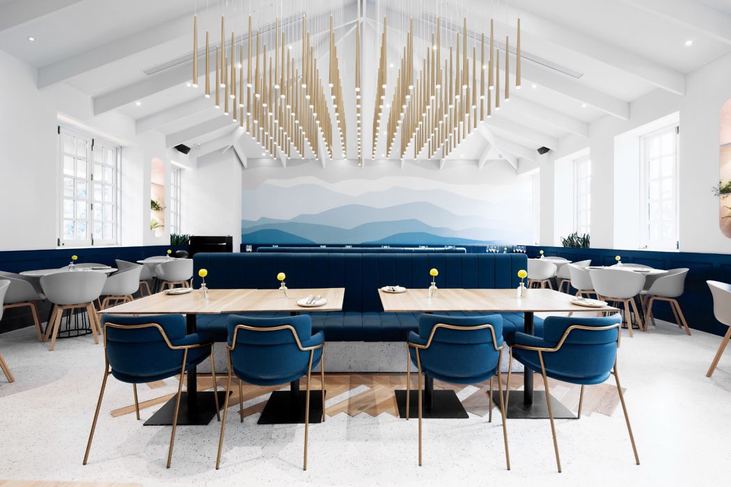 Modern dining room with blue chairs, wooden tables, and geometric ceiling light fixture.
