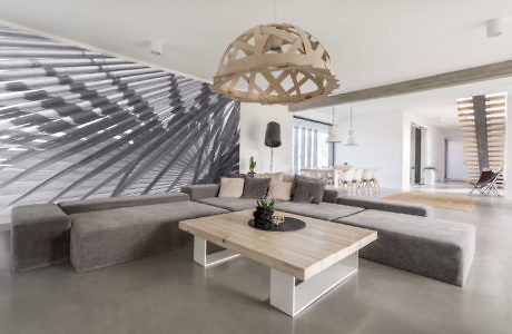 Modern living room with a large L-shaped sofa and a wooden ceiling lamp.