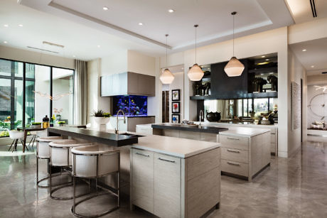 Modern kitchen interior with island, bar stools, and pendant lights.