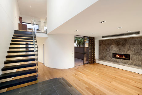 Contemporary interior with floating staircase and fireplace.