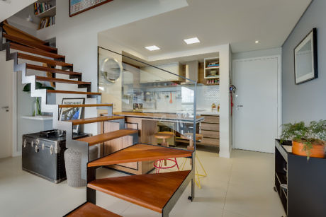 Modern interior with wooden staircase and open-concept kitchen.