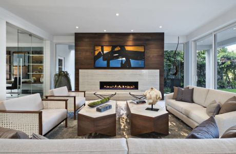 Contemporary living room with sleek fireplace and wood-paneled wall.