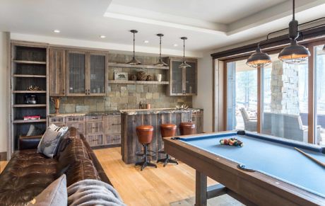 Modern home interior with kitchenette, pool table, and leather sofa.