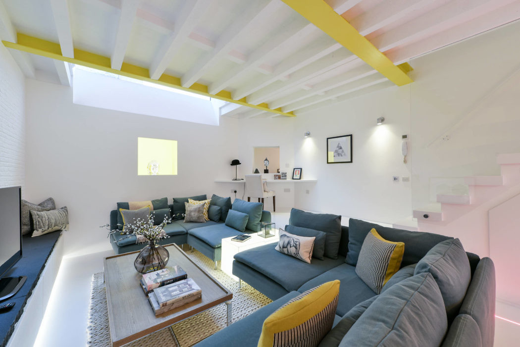 Contemporary living room with yellow beams and blue sofas.