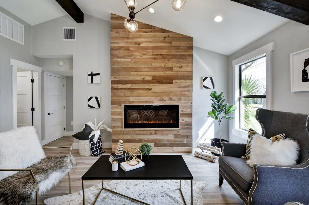 Modern living room with a wooden accent wall and fireplace.