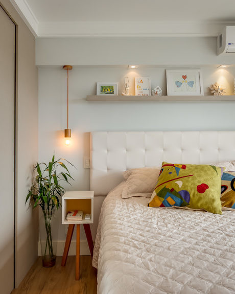 Contemporary bedroom with white tufted headboard, floating shelves, and pendant