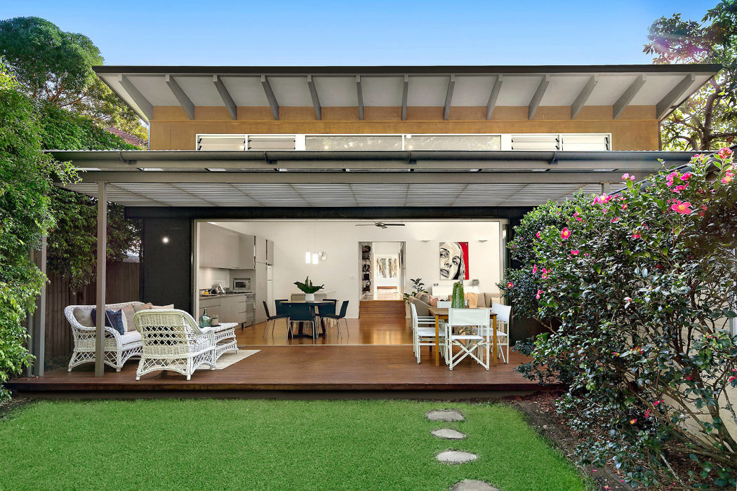 Contemporary home with open plan living space and large sliding doors leading to deck.