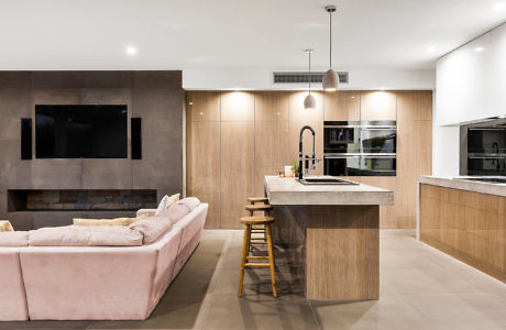 Contemporary open-plan living space with kitchen island and plush sofa.