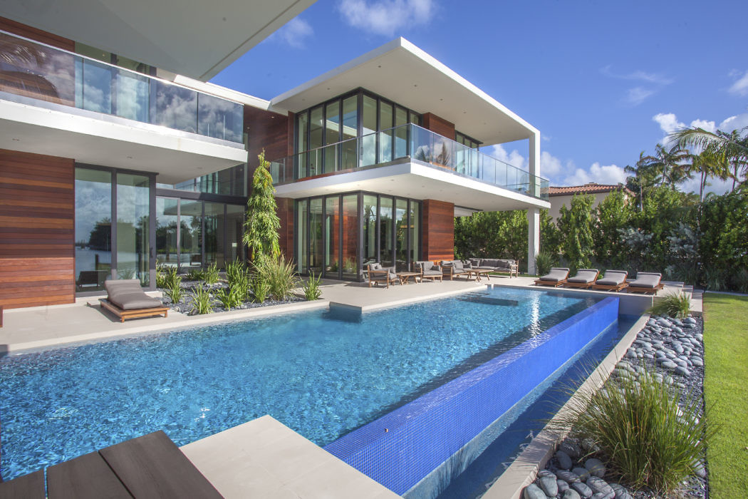 Modern house with large windows, pool, and wooden accents.