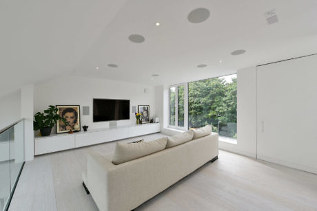 Sleek white living room with large windows and minimalist decor.