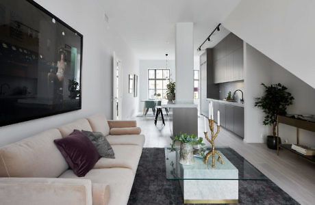 Contemporary living room with open kitchen and minimalist decor.