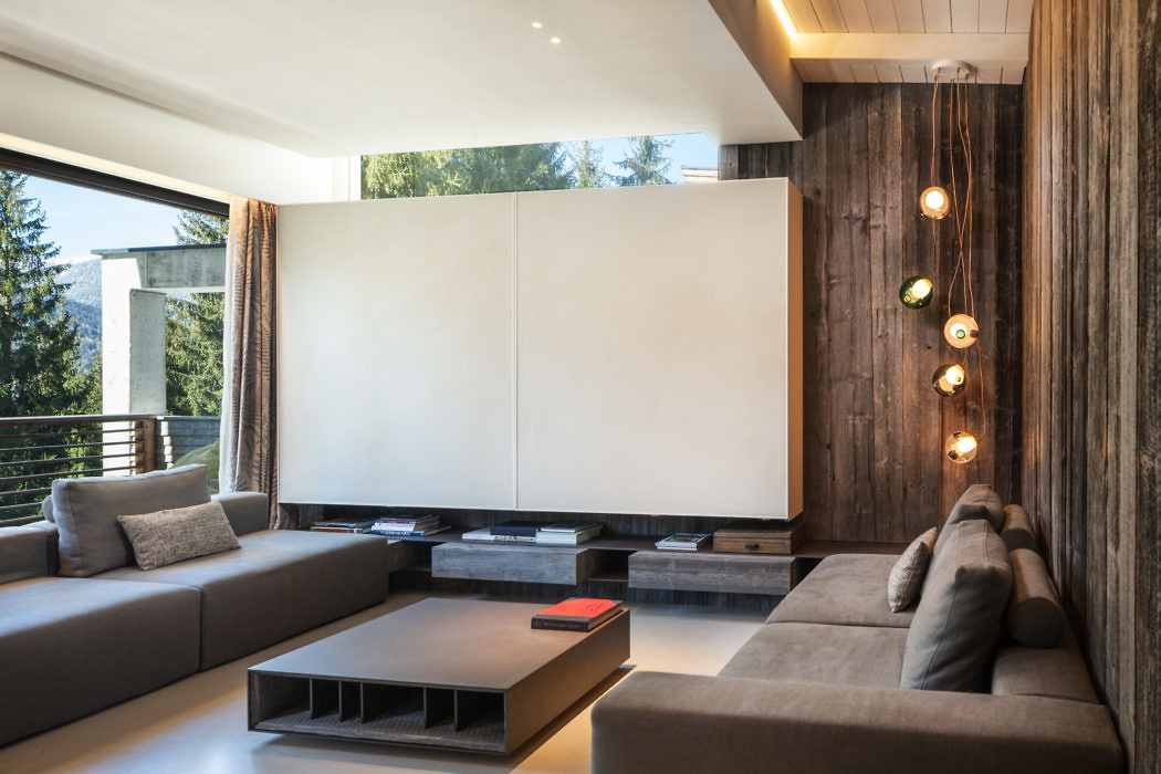 Modern living room with gray sofas and wooden wall.