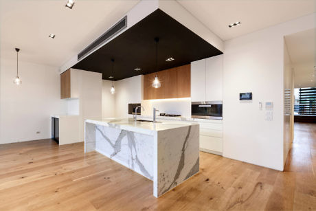 Sleek kitchen with marble island and wood floors