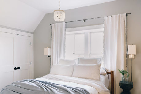Elegant bedroom with neutral tones and a cascading bead chandelier.