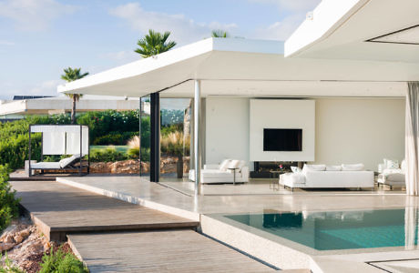 Sleek poolside villa with open-plan living space and retractable glass doors