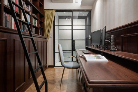 Contemporary home office with dark wood furnishings and built-in bookshelves.
