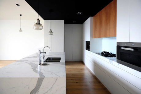 Sleek kitchen with marble countertops and wooden accents.