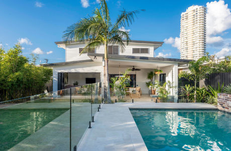 Backyard with pool, patio area, and a two-story house, under clear