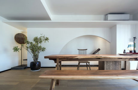 Spacious room with minimalist wooden table and plants.