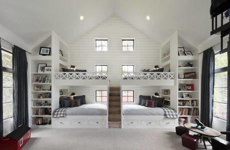 Symmetrical white bedroom interior with two loft beds, bookshelves, and large