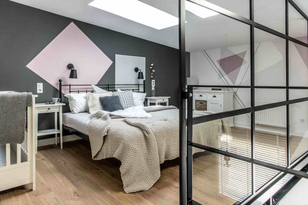 Contemporary bedroom with geometric wall accents and glass partition.
