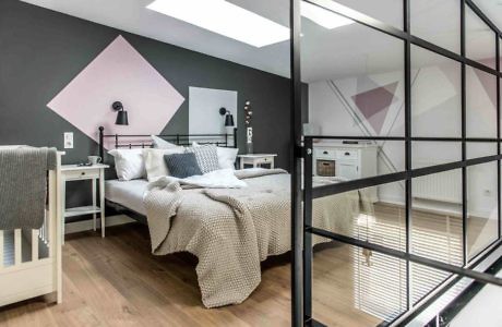 Contemporary bedroom with geometric wall accents and glass partition.