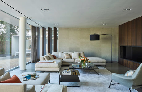 Contemporary living room with sleek furniture and floor-to-ceiling windows.